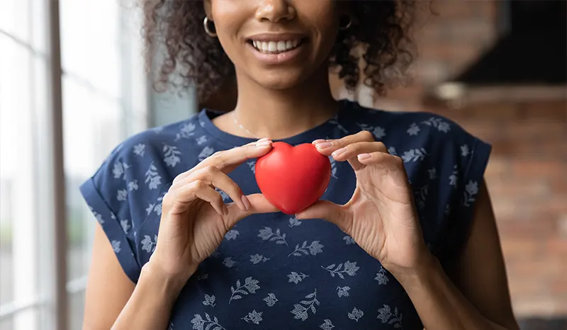 a young woman holding a heart figure in her hands